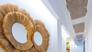 Un pasillo con suelo de madera, paredes blancas y dos adornos circulares en la pared.