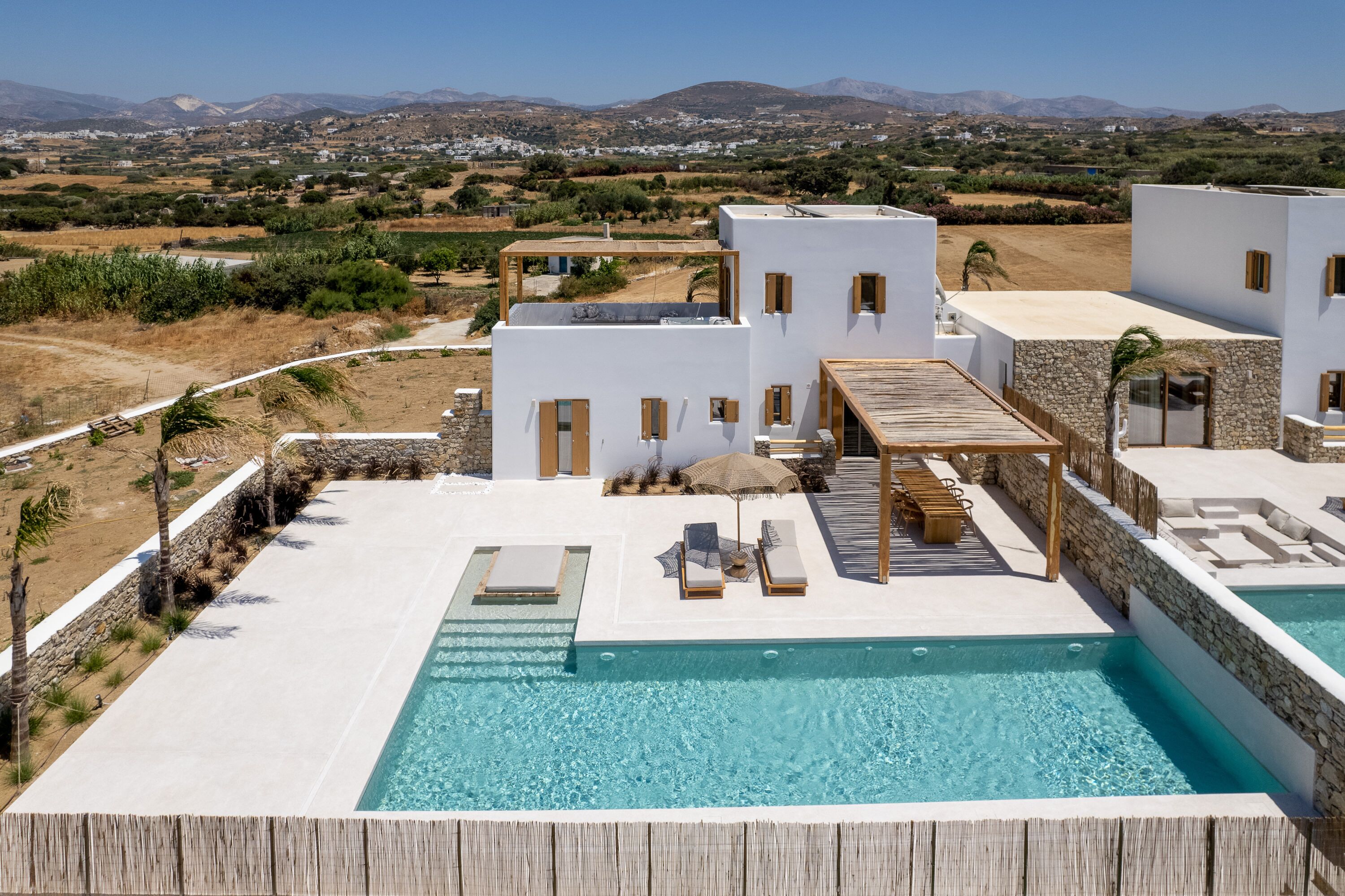 A poolside area with a clear view of the surrounding landscape, including buildings and mountains.