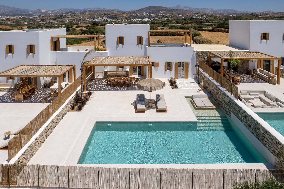 A rooftop pool area with a clear view of the surrounding landscape, including mountains and fields.