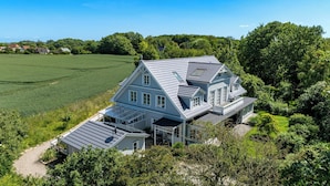 A large house with a sloped roof, multiple windows, and a well-maintained lawn. - Redewisch vacation apartment " Lee " (Boltenhagen/Redewisch)