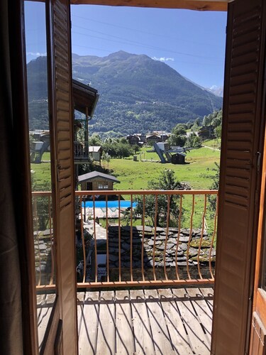 Maison de village au milieu des montagnes avec jardin.
