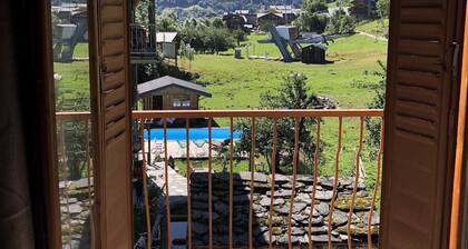 Maison de village au milieu des montagnes avec jardin.