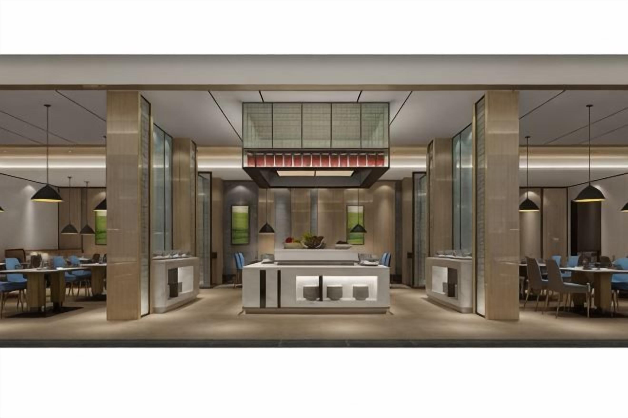 A modern hotel lobby with a central reception desk, seating areas, and a large window.