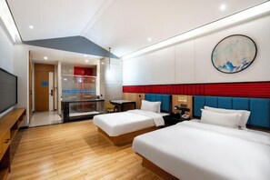 Habitació d'hotel amb dos llits, una taula de treball i una televisió.