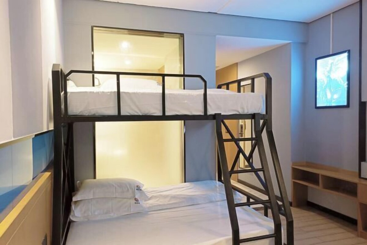 Camera con letto a castello, finestra, panca in legno e televisore a parete.