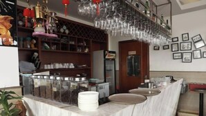 Una encimera de mármol con frascos de vidrio llenos de aperitivos, un refrigerador y un lavabo.