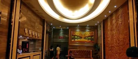 A lobby with a reception desk, a seating area, and a painting on the wall.