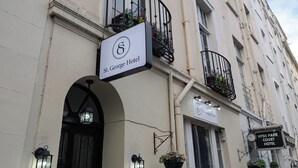 The exterior of St. George Hotel with a signboard, a balcony with flower baskets, and a neighboring Hyde Park Court Hotel. - St. George hotel (London)