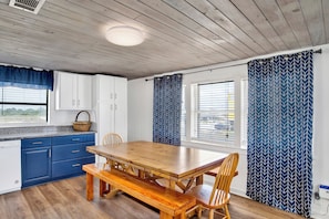 Enjoy meals at the dining table, surrounded by ample cabinetry and a window with blinds.