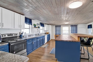 Enjoy cooking in this well-equipped kitchen with a central island, stainless steel stove, and oven.