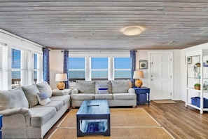 Relax in this stylish living room with a light gray sofa, blue and white throw pillows, and a dark blue coffee table.