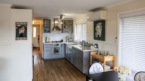 Une cuisine moderne avec des meubles gris, un plancher en bois et un îlot central.