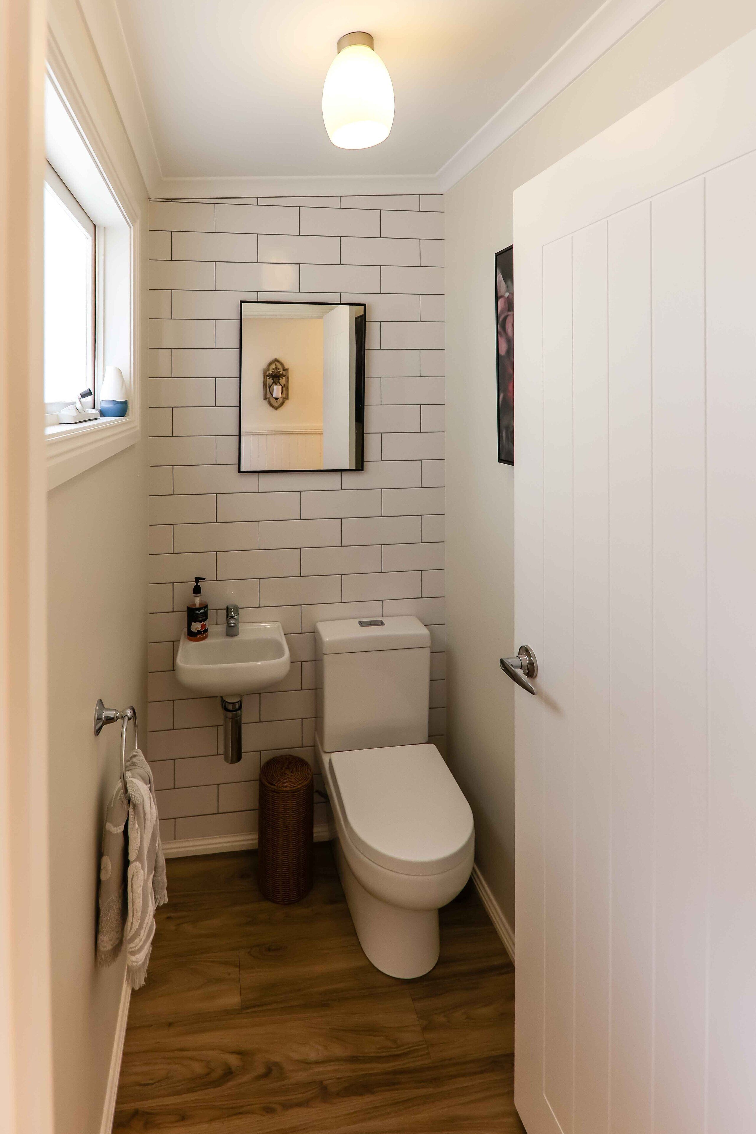 Un bagno piccolo con il water, un lavandino e uno specchio.