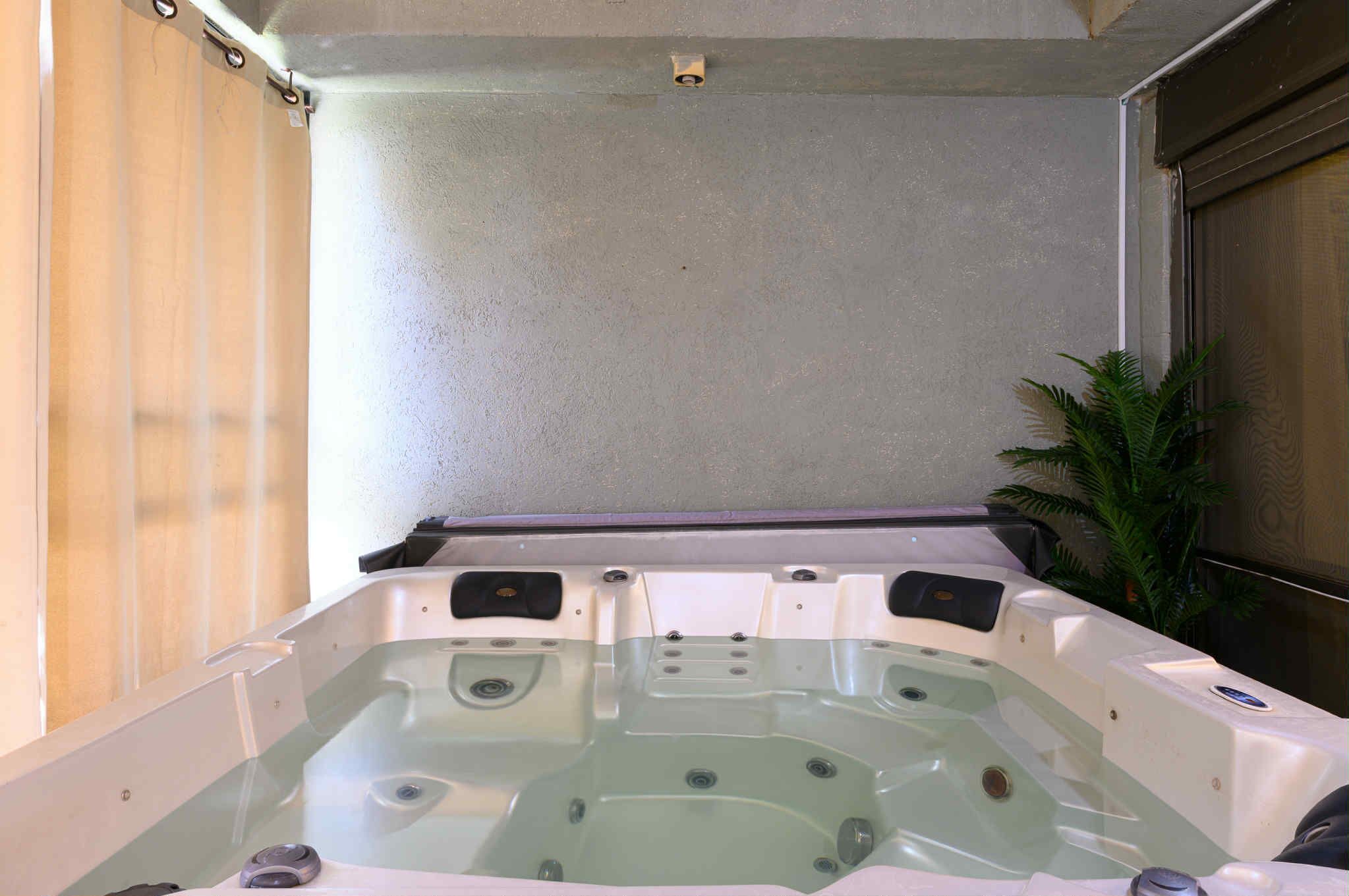 Een jacuzzi met meerdere zitplaatsen, een ingebouwde verwarming en een bedieningspaneel.