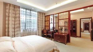 A hotel room with a bed, a desk, a chair, a wardrobe, and a decorative screen. - Chao Tian Hotel (Guangyuan)