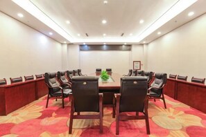 A conference room with a long table, multiple chairs, and a carpeted floor. - Chao Tian Hotel (Guangyuan)
