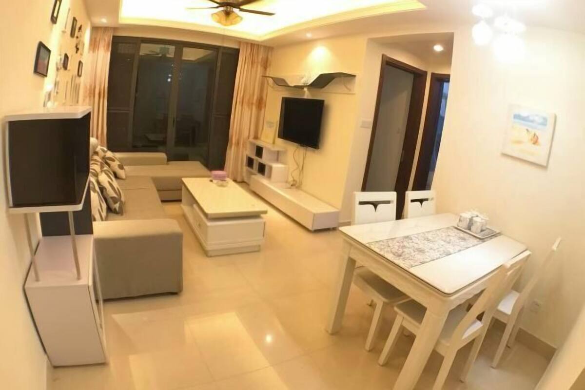 A modern living room with a sofa, TV, and dining table.