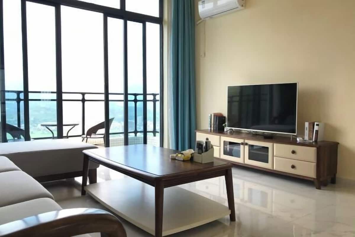 A living room with a sofa, a coffee table, a TV, and a cabinet.