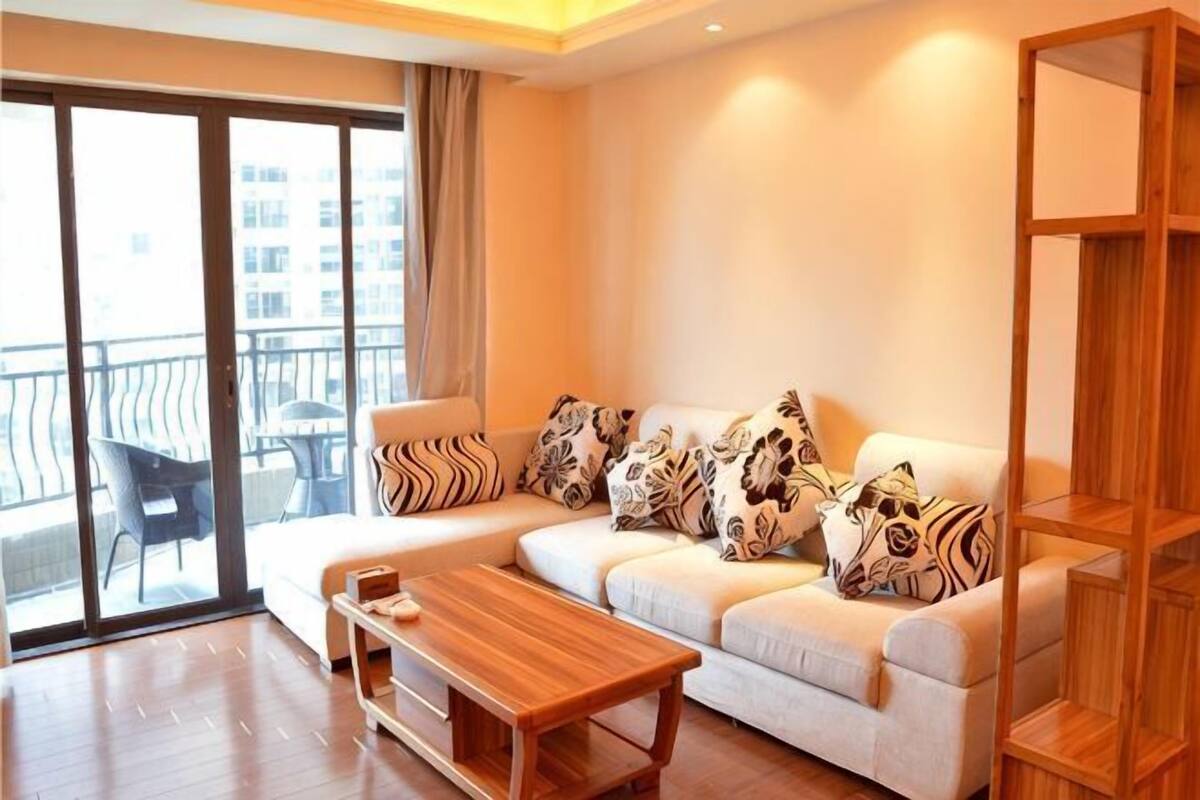 A living room with a sofa, a coffee table, and a wooden bookshelf.
