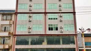 A multi-story building with a brick facade, large windows, and air conditioning units. - Hengxi Boutique Hotel (Dahua)