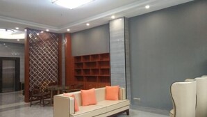 A modern lobby with a sofa, chairs, and a wooden partition. - Hengxi Boutique Hotel (Dahua)