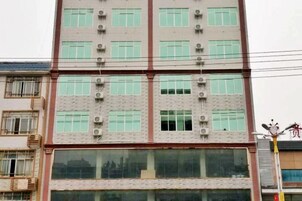 Un edificio de varios pisos con fachada plana, ventanas amplias y unidades de aire acondicionado.