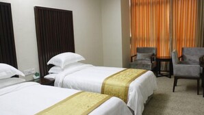A hotel room with two beds, a sitting area with a chair, and a large window with curtains. - Wenhai Hotel (Ma'anshan)