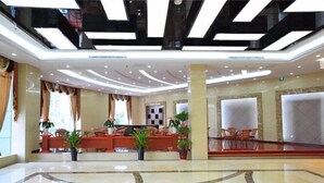 A spacious lobby with a modern ceiling design, a reception desk, and several seating areas. - Wenhai Hotel (Ma'anshan)