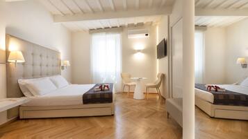 Ett hotellrum med två sängar, ett skrivbord, en stol, en TV och en luftkonditioneringsanläggning.