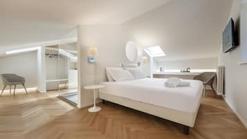 Una habitación de hotel moderna con una cama grande, un escritorio, una silla y un vestidor.