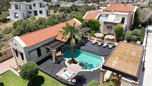 Μια σύγχρονη βίλα με πισίνα, εξωτερικό χώρο καθιστικού και θέα στη θάλασσα.