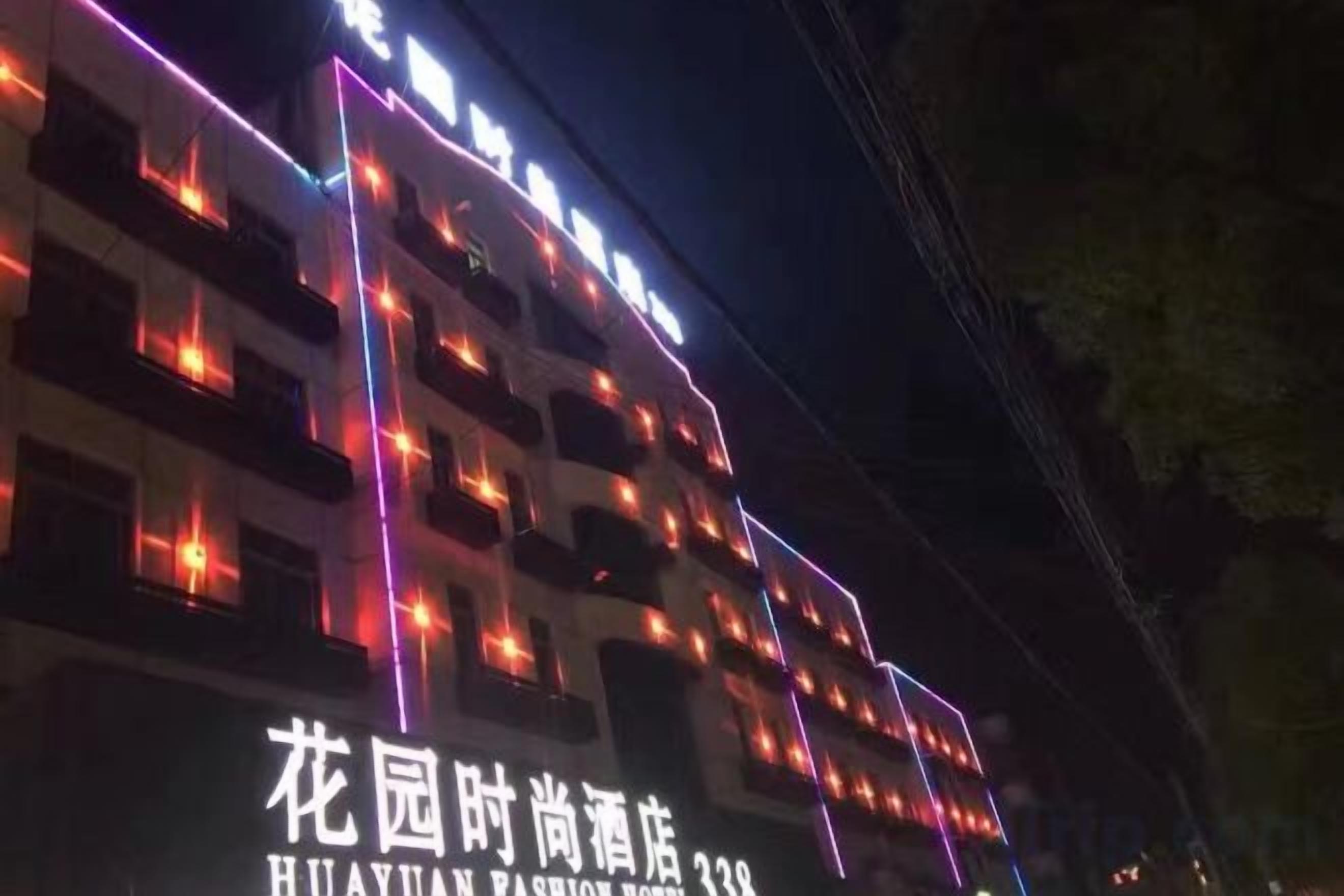 A multi-story building with illuminated signage and windows.