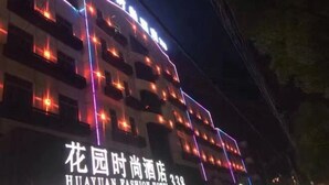 Een hotel met meerdere verdiepingen, verlichte signage en ramen.
