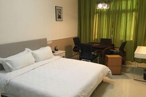 Une chambre d’hôtel avec un lit, un bureau, une chaise et une table.
