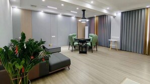 Een moderne woonkamer met een bank, eettafel, stoelen en een bijzettafeltje.