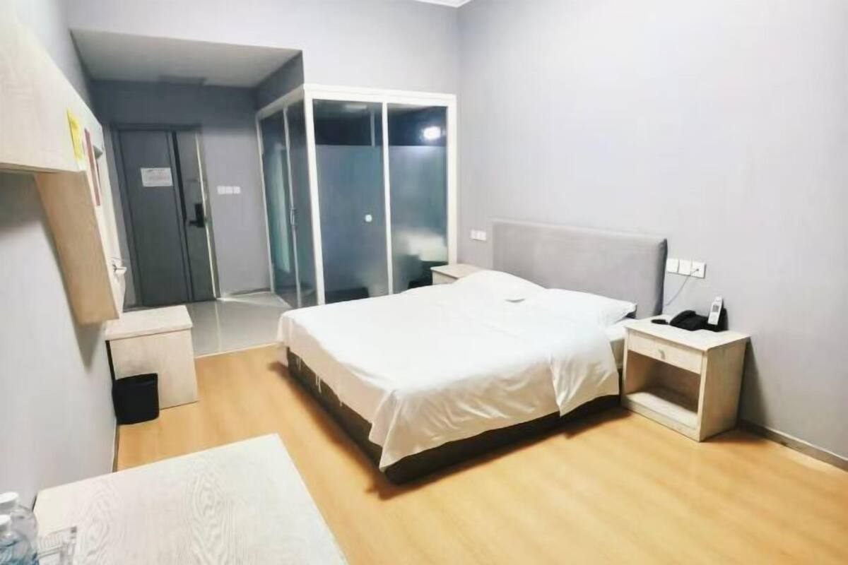 Ein Hotelzimmer mit Bett, Nachttisch und einer Garderobe mit Schiebetüren.