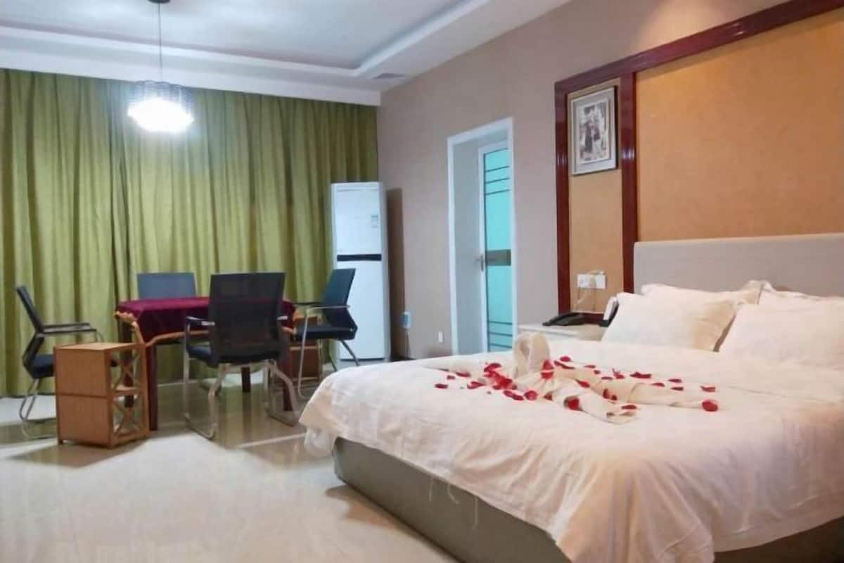 Ein Hotelzimmer mit Bett, Schreibtisch, Stuhl und Kleiderschrank.