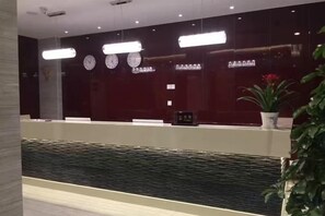 Un'area di accoglienza con reception, orologi e una fontana.