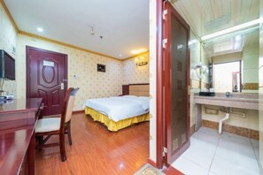 Cozy retreat with a comfortable bed, desk, and TV, perfect for a relaxing stay.