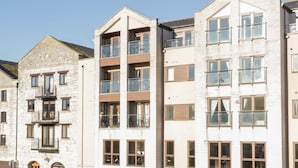 Un immeuble à plusieurs étages doté d’une façade en pierre et de balcons modernes.