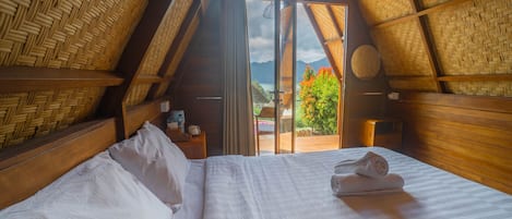 A room with a bed, a window, and a view of the outdoors.