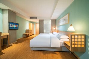 A hotel room with a large bed, a desk, a television, and a window with blinds. - NengHui Star Hotel (Guiyang)