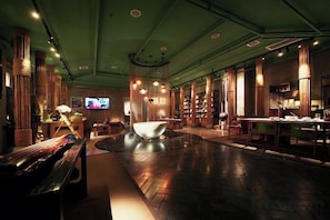 A spacious lobby with a central seating area, a television, and a large window.