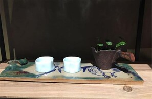 A ceramic tray with three white cups and a decorative pitcher with green plants. - NengHui Star Hotel (Guiyang)