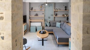 En moderne stue med en stenbuet åbning, en rund loftlampe, en sofa og et sofabord.