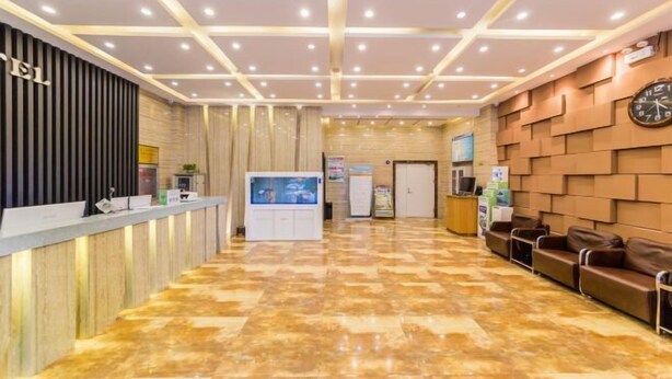 A hotel lobby with a reception desk, a digital information kiosk, a clock on the wall, and leather seating. - Yasidun Hotel (Hohhot Convention and Exhibition Center) (Hohhot)
