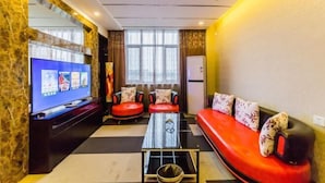A modern living room with a flat-screen TV, red and black sofas, a coffee table, and a large window. - Yasidun Hotel (Hohhot Convention and Exhibition Center) (Hohhot)