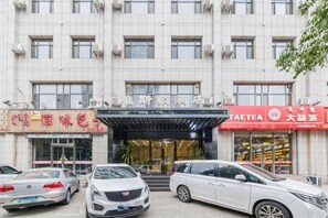 A building with multiple storefronts, including a tea shop and a restaurant. - Yasidun Hotel (Hohhot Convention and Exhibition Center) (Hohhot)