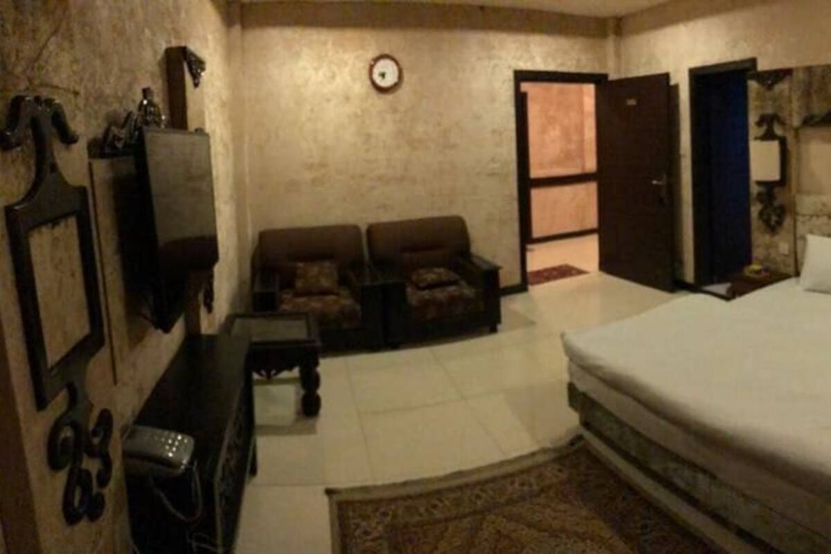 Ein Schlafzimmer mit einem großen Bett, einer Couch, einem Schreibtisch und einem Kleiderschrank.
