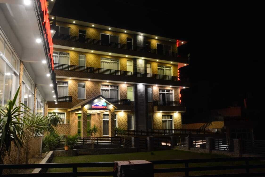Ein mehrstöckiges Hotel mit gut beleuchtetem Eingang und einem sichtbaren Schild.